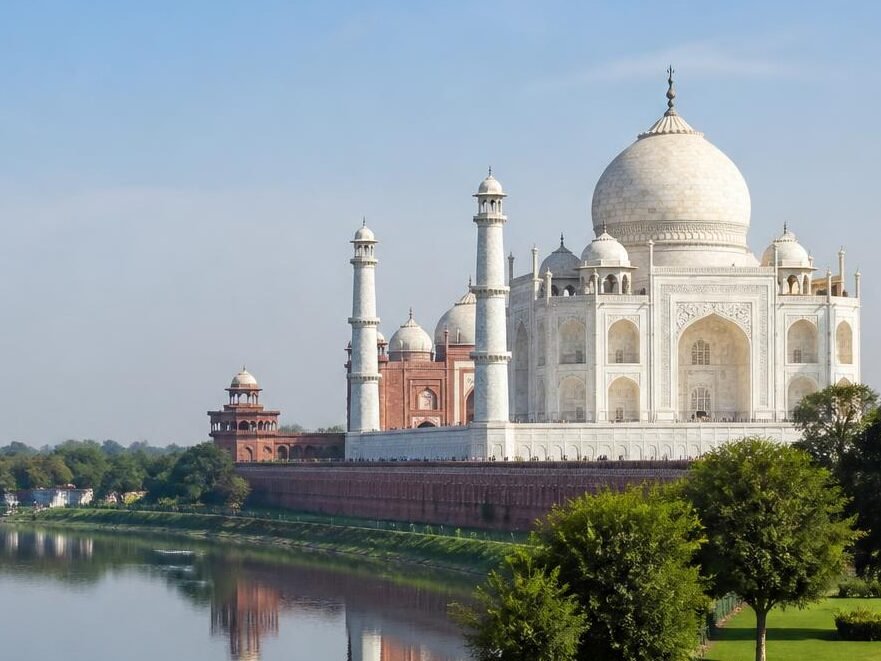 a realistic scenic photo of agra, uttar pradesh, featuring the taj mahal in soft daylight, with lush gardens, the yamuna river, and a clear sky