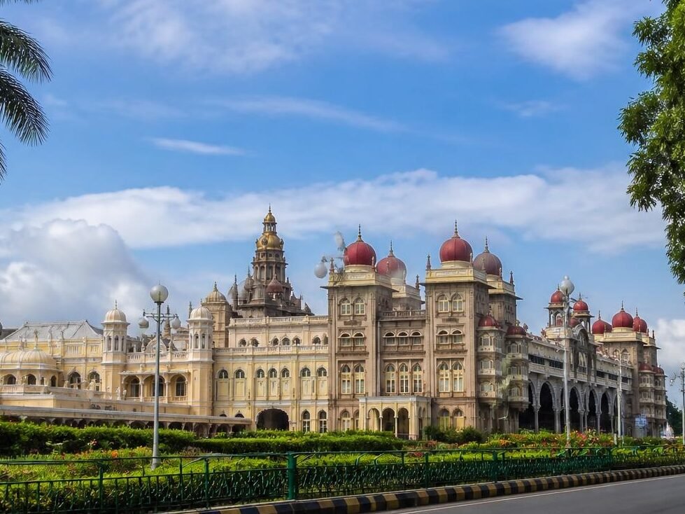 a realistic scenic photo of mysore, karnataka, featuring the mysore palace, clean city streets, lush greenery, and a bright daytime sky